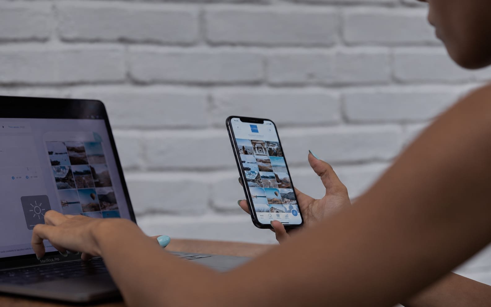 A person comparing a photo grid on a phone against a similar layout on a laptop screen